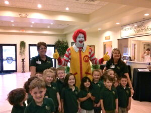 Ronald McDonald gives "thumbs up" to eager children in St. Johns County. Every year, Ronald reads to local child care centers to promote early literacy.